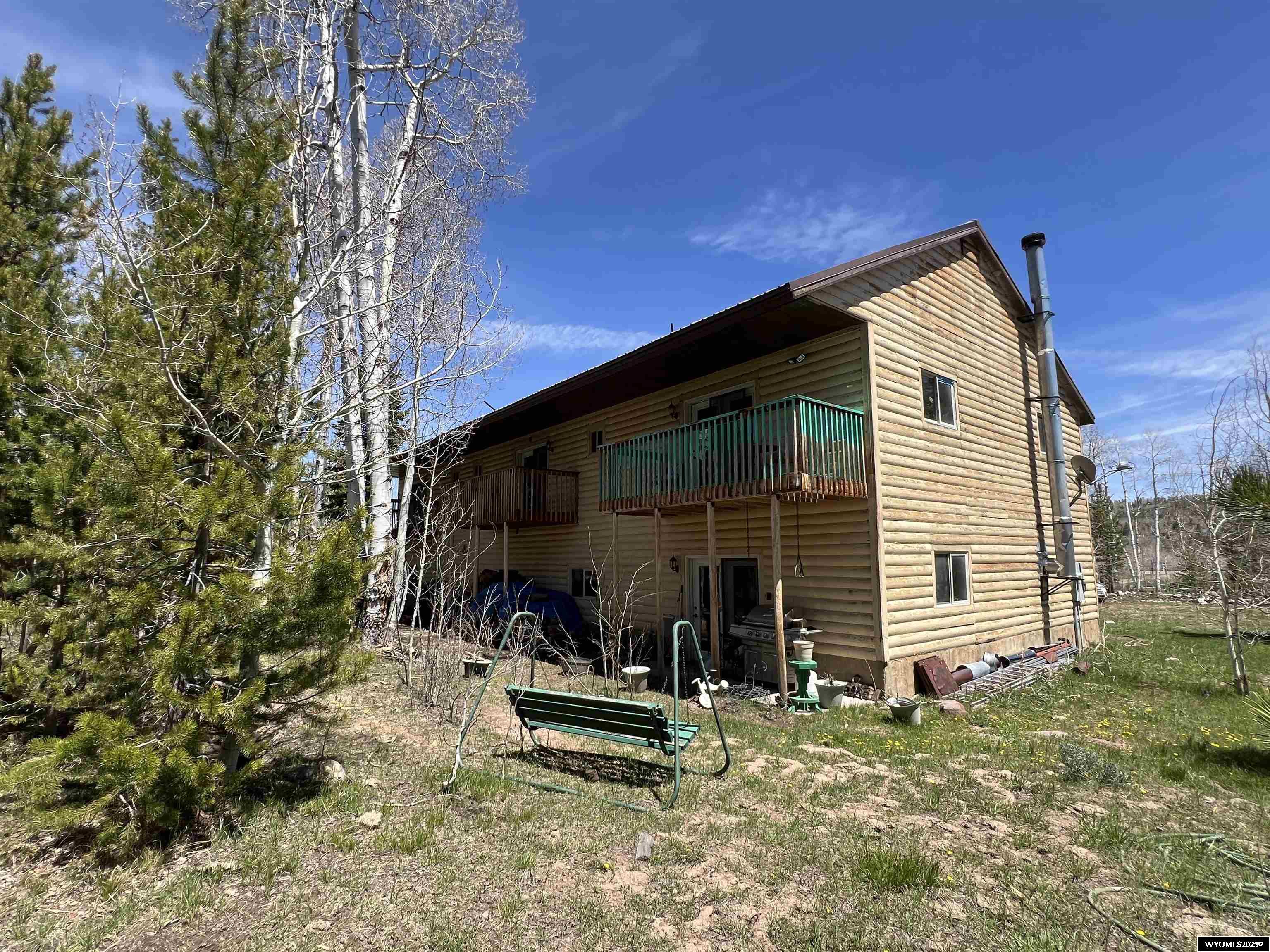 Discover the charm of this exceptional property, featuring two distinct cabins that blend rustic allure with modern elegance. The modern cabin boasts a stunning custom kitchen equipped with pull-out deep cabinets, a double oven, and luxurious in-floor heating throughout both levels. Enjoy the cozy ambiance provided by a wood fireplace, with the potential for up to 5 bedrooms and 4 bathrooms to accommodate family and friends. The three bedrooms upstairs all come with their own bathrooms, walk-in closets, and secluded balconies, offering a private retreat. Meanwhile, the rustic cabin offers a warm and inviting atmosphere with a kitchen, dining area, and living space on the main floor, along with one bedroom and bath. Upstairs, you’ll find 2 additional bedrooms and a loft, perfect for relaxation. Transform this unique dream oasis into your reality and create cherished memories for a lifetime. For inquiries or to schedule a showing, call Cowboy State Realty at 307-200-4332.