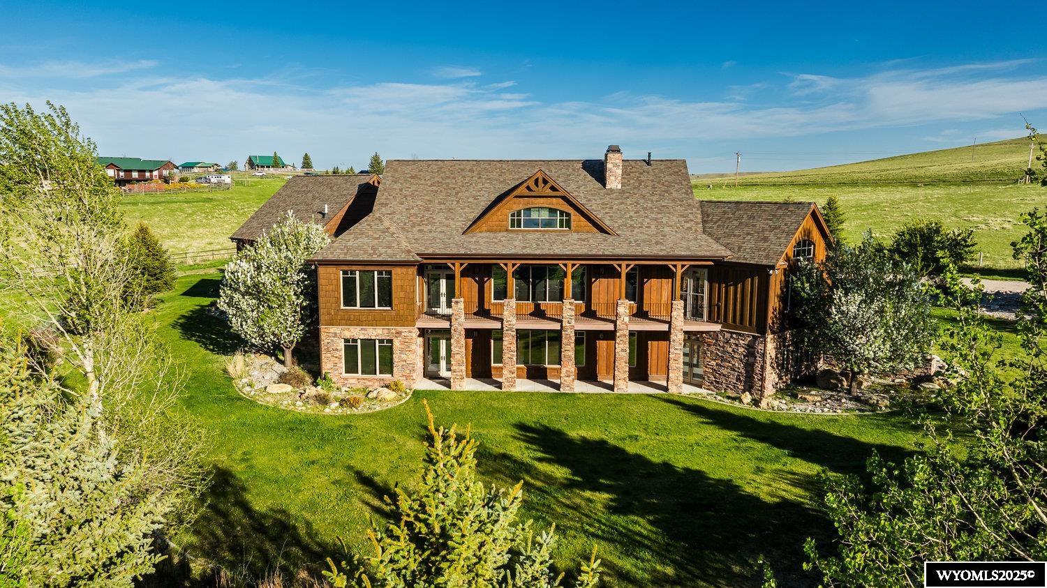 Welcome to Funny Bird Lane, located between the Johnson Creek and Sand Creek drainages at the foothills of the Bighorn Mountains.  This is more than just a home; it is a lifestyle surrounded by natural beauty.  Custom designed by Diamond Point Construction, this exquisite 4BR/4.5 BA masterpiece radiates warmth, natural light and thoughtful design. Beyond the front entrance awaits a welcoming stone fireplace warming a large living area, opening into an elegant chef's kitchen and formal dining, all with magnificent views.  The main level also features a large primary suite, second bedroom, 3/4 bath, private office, laundry area with sink and cabinetry for storage.  The loft area would be ideal for a reading nook or art studio.  The lower level, walkout basement offers a theater room, second kitchen and dining area perfect for memorable gatherings. Plus, two large bedroom suites with spacious closets, and an exercise room.  The home is heated with radiant floor heat for ultimate comfort.  A large balcony provides immediate access to the fresh mountain air and breathtaking views.  From the lower patio you will enjoy beautiful landscaping with a water feature, complimented by the natural beauty of the property.   Additional improvements include over 2,100 s.f. of shop space, plus a 600 s.f. loft, office with 3/4 bath and additional storage room.  Plenty of room for boat storage, all of your outdoor toys and barn needs.  Both home and shop have concrete wall construction.  The equestrian enthusiast will appreciate the post and rail perimeter fencing with ample pasture for two horses.  Outside the shop/barn is a hitching rail and plenty of space to customize your dream tack and feed room.  This 5 acre estate offers privacy and a harmonious blend of luxury and scenes of Wyoming's beauty.