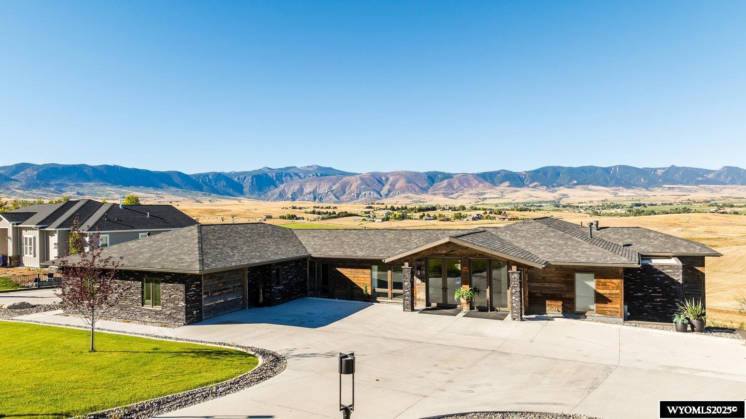 Nestled in the heart of the Powder Horn Golf Community in Sheridan, Wyoming, this stunning family home offers the perfect blend of luxury, comfort, and breathtaking mountain views. Whether you're a young family seeking a spacious, family-friendly environment or grandparents looking for a peaceful retreat with ample space for kids and grandkids, this home truly has it all.  Designed with family living in mind, the home boasts a full built-in movie theatre - perfect for cozy nights in or entertaining guests. A stylish bar adds a touch of elegance to the space, while the golf simulator offers endless fun for sports enthusiasts. The house features a covered deck and patio, offering unlimited possibilities for outdoor living - whether you're enjoying a peaceful morning coffee with views of the mountains or hosting friends and family for a sunset barbecue.  Located within the coveted Sheridan County School District #1, in Big Horn, Wyoming, this home offers the benefit of top-tier education, ensuring a bright future for your children. Plus, with downtown Sheridan just minutes away, you'll have easy access to charming local shops, restaurants, and cultural attractions.  Just minutes from Red Grade, the gateway to the Big Horn Mountains, this location offers unparalleled access to some of Wyoming's most sought-after outdoor activities. Whether you're an avid hunter, fisherman, or thrill-seeker, you'll find endless opportunities for adventure. From hiking and skiing to kayaking, camping, and even hang-gliding, the options are limitless. In winter, enjoy snowmobiling and ice fishing - making this home a year-round outdoor lover's paradise.  The Powder Horn community itself is one of the most desirable places to live in the United States, offering a relaxed, laid-back Western atmosphere combined with high-end living. Imagine the perfect balance of rustic charm and luxurious amenities, making this a truly exceptional place to call home. Whether you're looking for peace and tranquility or an active lifestyle filled with adventure, this property has it all.  If you're ready to embrace the beauty and lifestyle of Sheridan, Wyoming, this family home in Powder Horn is the ideal place to create lasting memories and live life to its fullest.