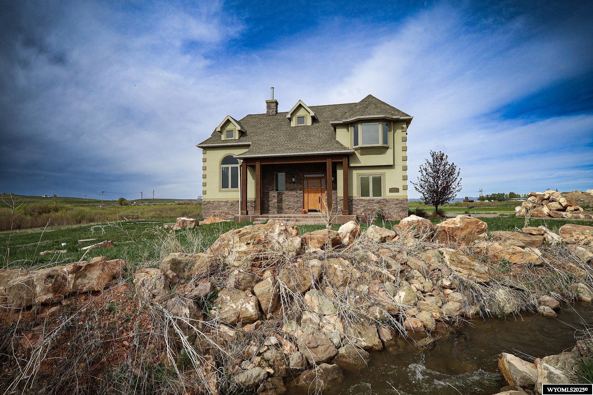 Discover the epitome of elegant country living on this magnificent 32.91-acre estate. This custom-built residence, spanning 4,700 square feet, offers 4 luxurious bedrooms and 3.25 well-appointed bathrooms. From the moment you step inside, you'll be captivated by the attention to detail and high-end finishes throughout.  The heart of this home is undoubtedly the gourmet kitchen; a culinary masterpiece outfitted with commercial-grade Wolf appliances, exquisite granite countertops, and an impressive suite of features including a warming tray, built-in espresso machine, and a convenient drink cooler. Whether you're hosting grand soirées or intimate family dinners, this space is designed for seamless entertaining and unparalleled culinary experiences. The open-concept living area ensures effortless flow and connectivity.  For ultimate convenience, a bedroom and full bathroom are thoughtfully located on the main level. A standout feature is the exceptional home office, a bright and inspiring space with tall ceilings, a comforting gas fireplace, and extensive built-in shelving, providing the perfect environment for productivity or quiet contemplation.  The residence is equipped with a home audio system, enhancing the ambiance in every room. Retreat to the spacious primary suite, a sanctuary offering breathtaking balcony views of the surrounding landscape. Unwind by the cozy gas fireplace or organize your wardrobe in the oversized walk-in closet. Indulge in pure bliss within the primary bath, featuring a lavish bathtub/jacuzzi with captivating color lights and a double shower equipped with a steamer for a truly spa-like experience. Three additional generously sized bedrooms provide ample space for family and guests.  The entertainment possibilities extend to the spacious walk-out basement, complete with a stylish wet bar – ideal for hosting memorable gatherings. Step outside onto the large private patio and take in the tranquility. But the allure of this property goes beyond the main residence. For the adventurous spirit, a thrilling dirt bike track awaits. Embrace sustainable living with a charming chicken coop, perfect for fresh eggs. Gather loved ones around the firepit for starlit evenings or explore the irrigated pasture that encircles this remarkable estate.   Contact Carter Pettit  at 307-288-0911 for showings and information