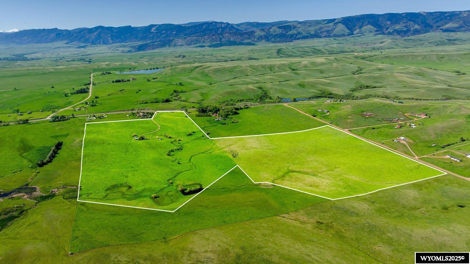 Rare to the market! 117 continuous acres of productive, sub irrigated pastures with unobstructed views of the Bighorn Mountains now being offered to the public. This quiet setting has so much to offer! The 4BR/2BA energy efficient home is situated in a quiet setting, full of south facing windows to admire the gorgeous mountain views.  Additional improvements include a detached 2 car garage, open faced shed with windbreak, horse pens and a great tack room for all your fine saddles and bits. The property features an abundance of water with four water wells, a spring fed pond, plus the South Fork of Five Mile Creek meanders thru the property to provide water for livestock and wildlife.  A seasonal intensive grazing program is utilized to keep the pastures in high yield from year to year.  This property is deeded as two parcels, one 47 acre tract and another 70 acre tract, giving buyers multiple options for use.  Come visit this beautiful property and see all it has to offer!