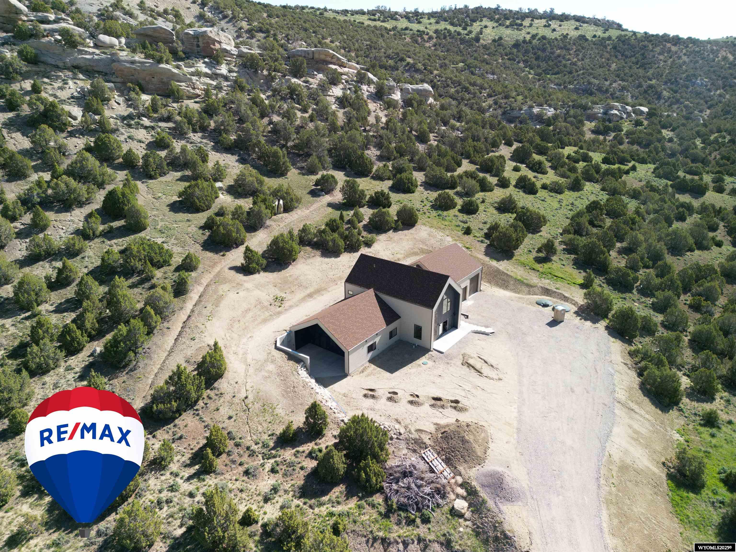 This is your chance to own a newly constructed Net Zero Energy Ready home in beautiful Lander WY! A net zero energy home is a residential building that generates as much energy as it consumes over the course of a year. In other words, the total energy produced by the home's solar panels offsets the energy consumed by the home's appliances, heating, cooling, and other energy needs. The primary goal of a net zero energy home is to achieve a balance between energy generation and energy consumption, resulting in minimal or no net energy consumption from the grid. In order to accomplish this objective, the home features highly efficient systems, assemblies and planning that is uncommon in Wyoming, but common in other areas of the US, Europe and similarly situated climates in Canada. This build includes technology from the University of Wyoming to implement technology to create an efficient, comfortable and beautiful home. To create as efficient of a building envelop as possible, this house was pressurized to 50 Psi on the interior of the home to locate and address any potential air leaks and scored a rating that put the home as the one of the “tightest” in the Rocky Mountain Region. Exterior wall assemblies include 2" of insulated and sealed zip sheeting and >5” of spray foam to provide an R rating of 45. Roof assemblies resulted in R ratings of 60. The multiple windows of this home are triple pane Alpen windows with European style hardware that allows the windows to tilt or fully open depending on your needs. One of the newest innovations that 42 Owl Canyon features is a highly efficient heat pump from Arctic Heat Pumps to heat and cool the floor slab. This system heats and cools with over 70% savings of traditional heating equipment which is again can be totally offset by a the solar system. Speaking of solar, this house is designed for a 15.5 KW system with 32-485Watt Panels on the roof along with 2-7.5 KwH battery storage units for plenty of energy at all times of year, day or night. The house is planned to be “grid tied” with battery backup so if you are generating a surplus of energy, the electrical company will let you build these funds up as credit on the account. During power outages, batteries can maintain electricity to the house and garage. The house also includes a ERV system to mechanically bring fresh air throughout the home and also exhaust air from the living space to create a healthy, self regulating interior climate. Finally, attention to orientation and sun location throughout the year will ensure strong passive solar heat gain through the winter and shading during the summer to help keep cool. Inside this beautifully finished custom home you will love the 9' ceilings throughout the main floor that vaults to over 32' high in the great room. All of this space is bathed in natural light thanks to the abundance of large triple pane windows facing all directions. The kitchen is all custom built Alder cabinets with soft close cabinetry, a large walk in pantry off the kitchen, and Black Granite countertops with a natural leather pattern. Best of all the island is 12'6"! When you walk in the front door you will be amazed at one of biggest great rooms around that features a view of the rocks behind the home that anchors this home to it's environment. The private Patio area off the primary bed is 32x16 covered space with 220v Hot tub hook up and massive sliding door. Upstairs the theatre room is ready for sound and projector and there is an area for a wet bar also. On the main there is 4 beds 3 full baths and in the non conforming 5th bed there is plumbing for a potential 4th bath installed already. Shop is 38x34 with a 12' door and 2-10's.  As of 2025 there is a Solar tax credit available to a Buyer to install your own Solar/Battery and that Buyer would get the Tax Credit. Or the Builder can install the above mentioned panels and batteries for an additional amount at cost. Call Skye Coleman-Weisz today at 307-851-0021.