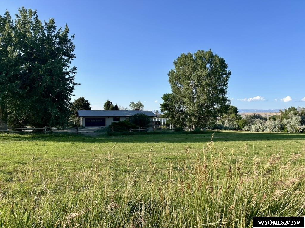Welcoming 15-Acre Ranch Property with Live Water, Horse Facilities & Country Home – Near Basin, WY  Welcome to your dream country retreat!   The spacious 4-bedroom, 3-bathroom home features an open-concept layout with large windows, bringing lots of natural light inside. Enjoy a cozy wood-burning fireplace in the living room, and a spacious master bedroom that opens onto the deck. The kitchen is ideal for entertaining, with ample counter space. The daylight basement, with many windows, offers a large family room with fireplace, a crafting room, 2 bedrooms, 1 bathroom, and lots of storage. Step onto the wrap around deck to enjoy your morning coffee, while enjoying the natural beauty around you.   The yard features underground sprinklers, a water feature with waterfall, 2 apple trees, and abundance of grass to enjoy.  Equestrian enthusiasts will appreciate the horse barn, with easy access to fenced pastures. A separate shop provides plenty of room for equipment, tools, or hobby space.  The land is fully fenced and includes irrigated grass pastures, ideal for livestock or hay production. Live water runs through the property, enhancing the landscape and supporting year-round agricultural use.  Whether you're looking for a recreational getaway, or a quiet homestead, this property offers it all—serene rural living with modern amenities and unmatched Wyoming charm.
