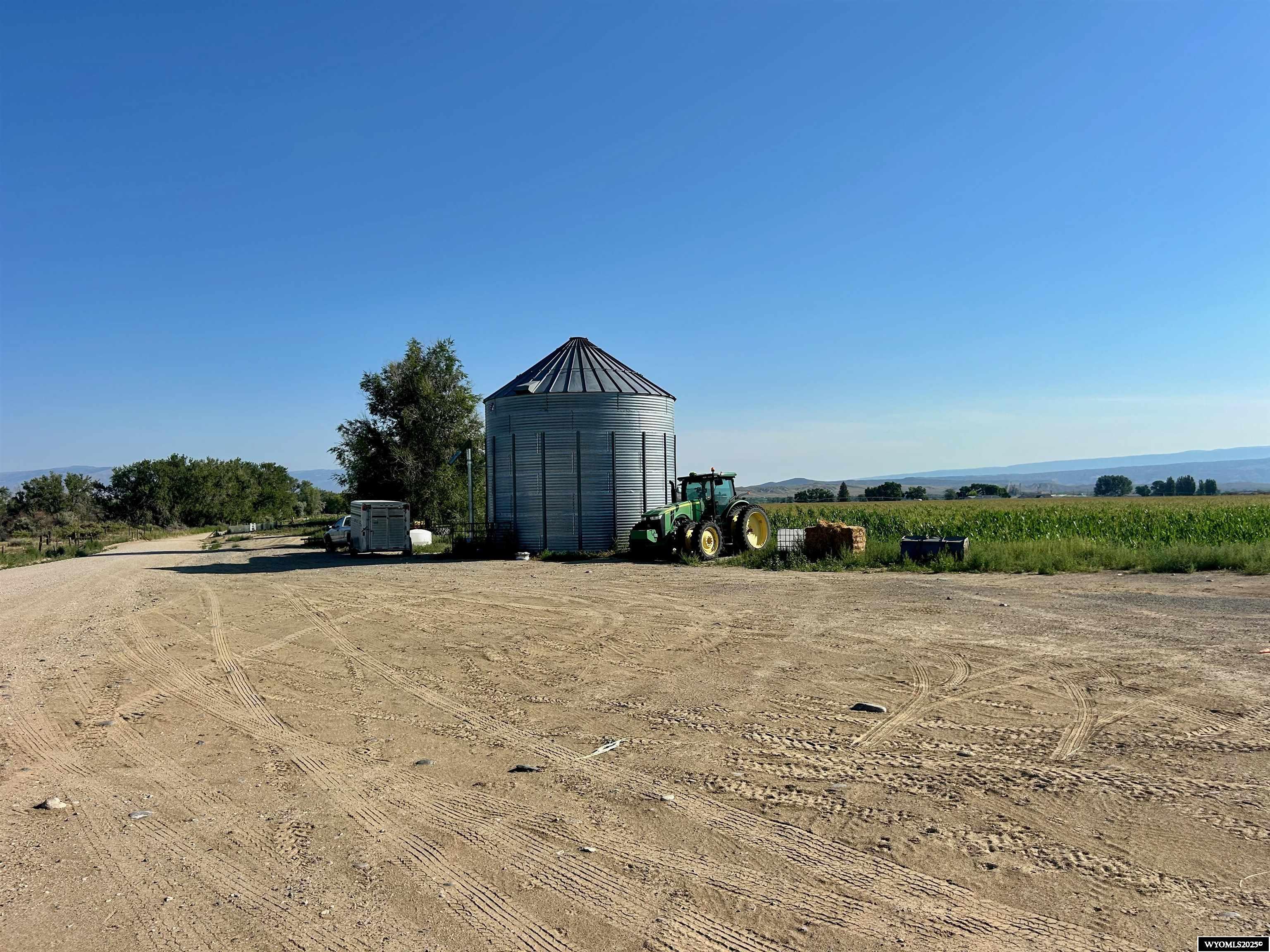 This 237-acre property is located near Lovell in Big Horn County, Wyoming, with direct access from both Highway 14A and County Road 13. Of the total acreage, approximately 229 acres are irrigated, offering substantial agricultural production potential. The terrain includes a mix of level ground and gently rolling areas, making it suitable for a variety of agricultural and rural land uses. A natural spring adds to the land’s utility and resource value. With strong water availability and access, the property is well-suited for row crop production, hay, or pasture management. This property presents opportunities for multiple uses, including as productive farmland, a future homesite, or a long-term investment in irrigated ground. The large acreage and reliable irrigation support a working agricultural operation. Additionally, the open terrain and easy access make it practical for development of rural infrastructure or residential plans. This property includes a 2800 sq ft quonset shop, with 1 bed, 1 bath apartment, and an 18,000 bu grain bin. There is a possibility of more lease acres available. The property is situated approximately 6 miles east of Lovell. Cody is approximately 49 miles away and provides regional airport access and expanded amenities. This tract of land represents a sizable holding in a part of Wyoming known for its agricultural productivity and access to outdoor recreation. Big Horn Lake, Pryor Mountains, and the Big Horn Mountains, are a short distance away.