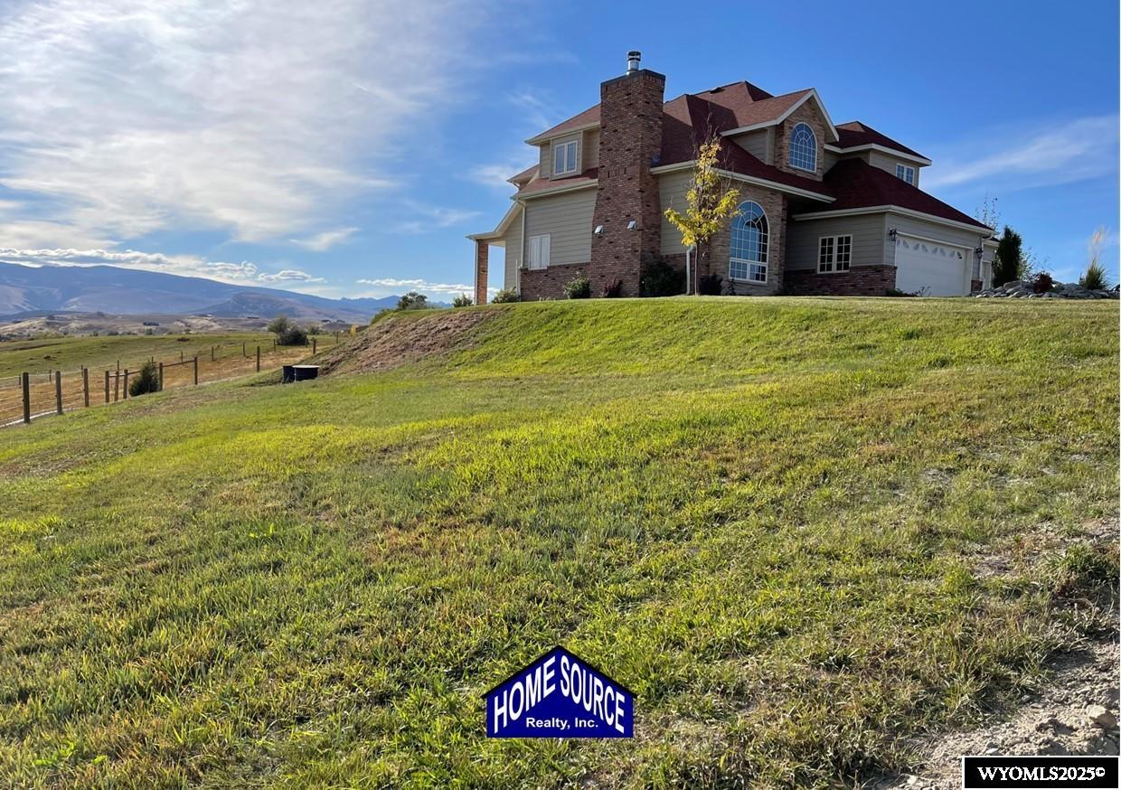 This home is stunning in its quality, impressive in its views and welcoming in how it feels. Situated on a gorgeous 1.5+/-  irrigated acres, this is a rare opportunity to purchase custom construction that is surrounded by maintained, green productive grassland and an on-top-of-the world panoramic view of the full Lander valley. The traditional style, warm colors, gorgeous hand scraped red oak solid hardwood flooring and appealing floor plan make the home attractive and inviting. The kitchen, dining room, den and living room are all excellent and well-defined gathering areas, positioned to capture the magnificent views, and also well-thought for furnishings and home décor. The lovely kitchen has quality cabinetry, island with granite counters, stainless steel appliances and an open dining area that keeps everyone together. The outdoor living is sensational; the patio doors open up to unmatched views of pasture, mountains, green rolling hills and a bird's eye view of the City of Lander. There's ample natural light throughout, and the upgraded clad casement windows frame the view beautifully and thoughtfully in every room. The 9’ high ceilings on the main level, with cathedral ceilings in multiple main-level rooms, and including cathedral ceilings throughout the full upper floor, make the home feel light and open. The grand brick hearth fireplace and the notable hand-built freestanding hanging circular staircase are some of the striking upgrades of this home. The primary bedroom has a luxurious on-suite bathroom, complete with platinum water jet package two-person tub, sizable and tasteful tile shower and a walk-in closet. Construction details include: two forced air and central air systems for efficient temperature control, whole house humidifier, 2'x6' exterior walls, full-house foam insulated (ceiling, walls, crawlspace), French drain system, on-demand hot water and 960’ deep plentiful and quality private well. This property has it all! It has complete landscaping and a 3-car garage. It’s also like-new in condition, custom in construction detail, upgraded in components and located on a rare piece of productive land with scenic views of wildlife and the Wind River Mountains. **The purchase must be contingent upon the successful replat of the property through Fremont County Planning. Additional acreage may also be available for sale together with the closing of this property. Contact agent for details.