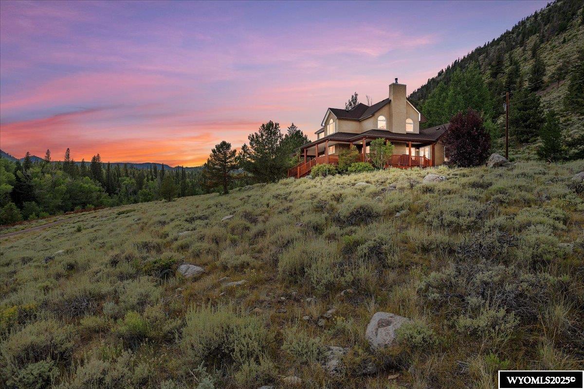 Serene Mountain Retreat – Resort-Style Living on 26+ Acres. Escape to your own private mountain sanctuary with this stunning 2-story stucco home nestled on 26.06 acres of pristine Wyoming wilderness. Surrounded by breathtaking natural beauty, this resort-style property borders National Forest with a portion of The North Fork of the Little Laramie River flowing through the property. Step inside to discover soaring 20-footpine cathedral ceilings, expansive windows that flood the home with natural light, and panoramic views from every room. The open-concept living, creates a seamless blend of rustic charm and modern comfort. Enjoy peaceful mornings and starlit evenings from the wrap-around deck.  Whether you're relaxing indoors or exploring the surrounding forest and riverbanks, this home is a true haven for outdoor lovers and those seeking a peaceful retreat.
