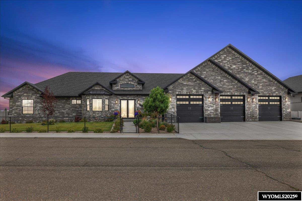 Nestled on a sprawling .60-acre flat lot, this stunning 3-bedroom, 3.25-bathroom residence spans 3,767 square feet of refined living space on one level, offering an unparalleled blend of elegance and functionality. Designed for those who appreciate luxury and practicality, this home boasts an array of premium features, seamlessly blending timeless sophistication with modern conveniences.  Step inside to discover 10-foot ceilings throughout, adorned with custom alder trim and solid-core 8-foot alder doors, exuding craftsmanship and warmth. The great room captivates with 13-foot beamed ceilings, a stylish paddle fan, and soaring vaulted ceilings that enhance its grandeur, making it perfect for entertaining or unwinding in style. The open-concept kitchen, a chef’s dream, features a large island, state-of-the-art Monogram appliances, a Sub-Zero refrigerator, an induction cooktop, and a pot filler with a custom herringbone tile backsplash. Distressed alder cabinets, complete with toe-kick, under-cabinet, and upper-cabinet lighting, dual sinks, an ice maker, and gleaming granite countertops, create a stunning and functional culinary space that flows seamlessly into the living and dining areas.  Cozy up by one of the four fireplaces, each thoughtfully placed to add charm and comfort throughout the home, from the exquisite office to the welcoming family room. The primary suite and office elevate luxury with custom tin ceilings, while the primary suite and hot tub room feature exquisite porcelain tile flooring. Indulge in relaxation in the dedicated hot tub room, designed as a private oasis with ambient lighting and serene views of the lush surroundings. Movie enthusiasts will revel in the state-of-the-art theater room, equipped with a speaker system and plush seating for cinematic experiences at home.  The meticulously landscaped grounds, maintained by a 10-zone sprinkler system, feature vibrant garden beds, trees, and a spacious patio, providing a serene backdrop for outdoor entertaining or tranquil evenings under the stars. The heated 3-car attached garage boasts epoxy flooring, a flooring drain, 220V, and hot and cold-water taps. The expansive 3,850-square-foot detached shop, measuring 55’x70’, is a rare gem, featuring two 12-foot doors, one 14-foot door, overhead radiant tube gas heat, LED lighting, a bathroom, 50-amp RV hookups, and sewer dumps both inside and outside, making it ideal for car enthusiasts, hobbyists, or additional storage.  Two bedrooms are in a separate living area accessible via the garage. This area, complete with its own kitchen and bathroom, offers versatile space for guests or extended family. The home is equipped with a comprehensive smart home system, including a Sonos in-house speaker system and a state-of-the-art security system, ensuring convenience, entertainment, and peace of mind. Energy-efficient features, including smart home technology and Pella windows, ensure year-round comfort and sustainability.  This exceptional estate combines sophisticated design with versatile spaces, making it the perfect sanctuary for modern living. Whether hosting grand gatherings or enjoying quiet moments of luxury, this home offers an extraordinary lifestyle. Don’t miss the opportunity to own this masterpiece of comfort and style— call Cody Ferrin to schedule your private tour today!? 307.679.5115. Buyer or Buyer's agent to verify all information.