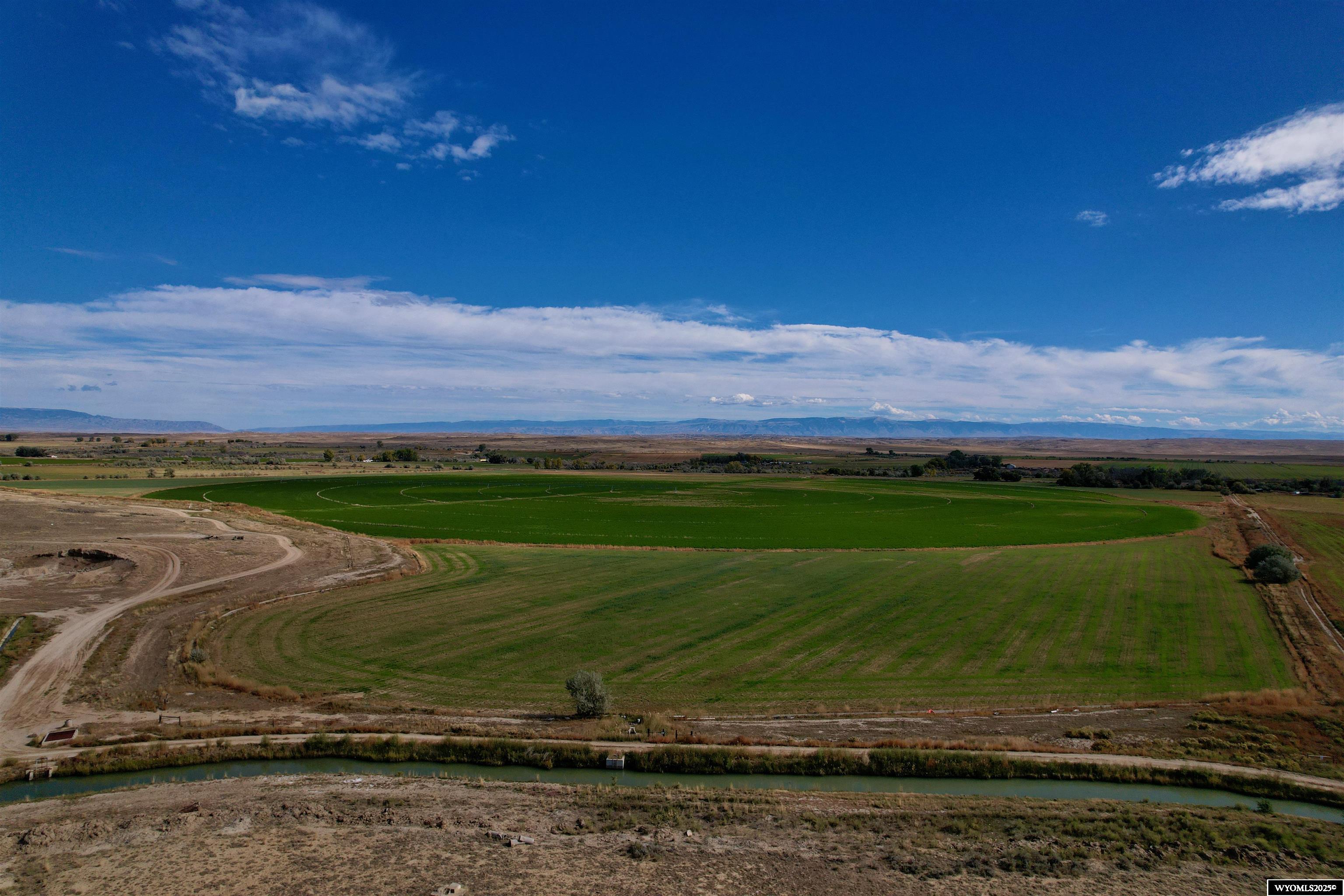 Located just outside Powell in Big Horn County, Wyoming, this 328-acre property offers a rare combination of irrigated farmland, recreational opportunity, and public land access. With approximately 190 acres under irrigation, 130+/- acres under pivot irrigation and 60+/- acres in flood irrigation, the property has a strong foundation for agricultural income or operational use. The pivot is currently planted to a hay/grass mixture.  There is live water for cattle out of Whistle Creek. The remaining acreage consists of pasture, creek bottom, and transitional ground with multiple potential building sites.    Whistle Creek flows through the property, enhancing its utility for both agriculture and wildlife habitat. Water rights support the irrigated acreage, which is currently utilized for crop production and can accommodate a variety of agricultural practices. The level terrain and access to water also make this property adaptable to rotational grazing, hay production, or other income-producing land uses.    The parcel is bordered by public land on the western boundary, providing direct access to hundreds of additional acres for hunting, hiking, and other recreational activities. The area is known for its upland game and big game species, and the creek corridor provides additional habitat value.    The property offers direct access from a nearby highway, allowing for convenient year-round entry. Utilities are accessible on the property, supporting residential or agricultural infrastructure development. Scenic views of the nearby mountain ranges add to the location's appeal for those seeking a rural homesite with functional land attributes.    Powell, WY is located approximately 15 miles from the property, providing access to essential services, schools, and agricultural support businesses. Cody, WY is about 30 miles away and offers additional commercial services as well as an airport with regional connections. Billings, MT, a larger metropolitan area, is located roughly 100 miles to the north and provides access to major services and infrastructure.    This property presents an opportunity for a buyer seeking land with productive capacity, recreational utility, and potential for residential development. Whether used for farming, ranching, hunting, or a combination of purposes, the acreage and location provide flexibility and long-term value.