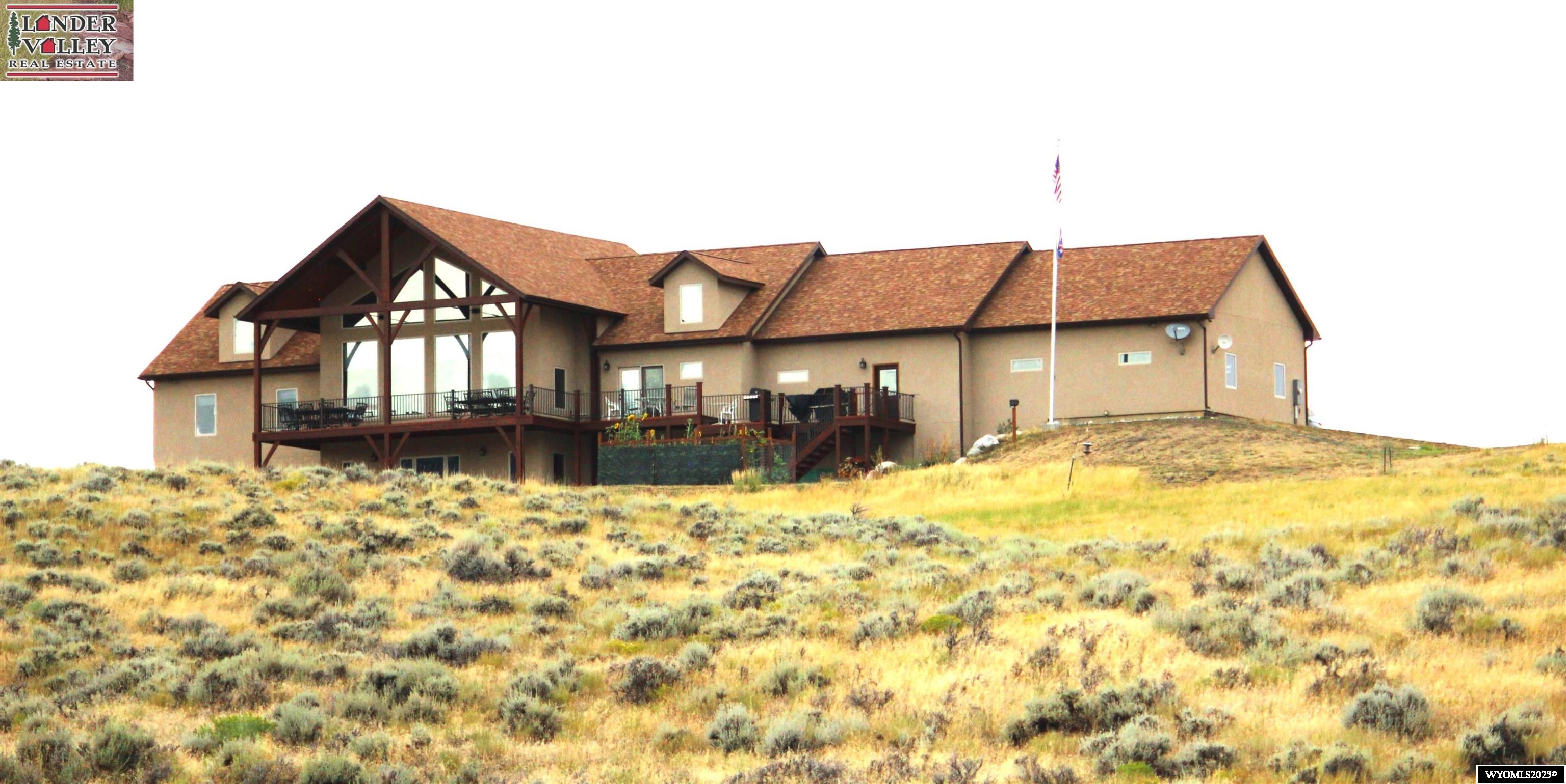 Elk Run at Sinks Canyon Ranch is a custom-designed, custom-built timber frame style home of approx. 6,210 sq. ft. of quality construction. Perched on 35 acres overlooking valleys and mountains, it adjoins 440 acres of public land/school section which expands your enjoyment and privacy. Elk Run at Sinks Canyon Ranch captures 360 degrees of breathtaking views, while being just a few miles from city limits. Highlighted by vast windows and vaulted ceilings, the views also include various wildlife species.     The home is high quality "Like New" condition throughout with unlimited storage, thoughtful details and conveniences such as Cat 6 Ethernet, a Great Room wired for Dolby 5.1 sound, engineered wood hickory flooring and porcelain tile, closed-circuit surveillance cameras, an alarm system, a detached observation deck, a whole-house reverse osmosis system for the private well, and a four-car heated garage with direct access to the woodshop and first floor. The large walk-in pantry off the beautiful "Chef's Delight" kitchen provides more than ample storage cabinets.     Stepping into the beautiful entry hall and staircase, you are drawn into the stunning Great Room. This grand living space, with its large stone gas fireplace, provides lots of seating and gathering areas—either cozying up to the fire or gathering in front of the large span of windows overlooking Sinks Canyon and the Wind River Mountain Range.     The open floor plan leads to the kitchen and dining area, perfect for entertaining or casual gatherings around the kitchen island/bar. Any cook will be delighted with the features in this well-equipped kitchen, which includes gorgeous hickory cabinetry, quartz counters that span large spaces, and quality appliances. The dining area, with a built-in hickory china cabinet, easily seats a crowd and provides access to this level’s outdoor deck. The primary bedroom suite is found on this level. Among other amenities, the primary bath has a jetted tub, a fully tiled shower with stone accents and seating space, and double sinks on the vanity with plenty of cabinetry. A walk-through closet leads to the laundry room for convenience. A second bedroom and guest bath can be found as well. This entry level leads up to a third-floor loft area that overlooks and opens to the Great Room.      The walk out level (labeled 1st Floor on floor plan) provides another full floor of square footage, made up o f two large bedrooms, a third bathroom, storage and hobby areas, plus a real bonus—a wood shop/workshop (approx. 585 sq. ft.) with an air filtration system and equipment.     The seller would like to include most woodworking benches, major machinery, John Deere Gator/ with 6 ft snow blade, and John Deere Riding mower.   The bonus room (approx. 853 sq. ft.) gathering room and office finish out this level, offering plenty of space for a theater room, game room, library, or office, complemented by a wood stove for cozy wintertime relaxing. This  room has direct access to the outside patio and south yard.